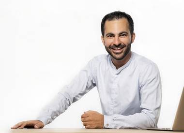 WordPress expert Hamed Farhadian smiling at his laptop