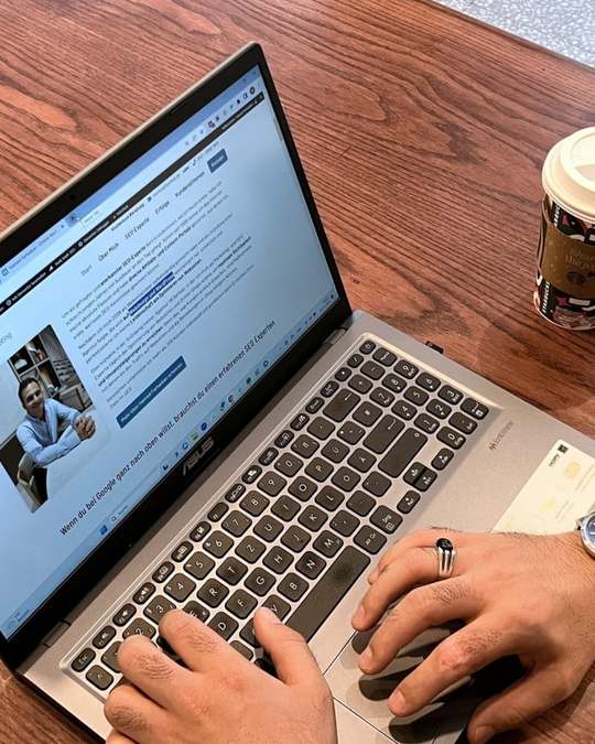 Hamed Farhadian arbeitet am Laptop an einer Website.