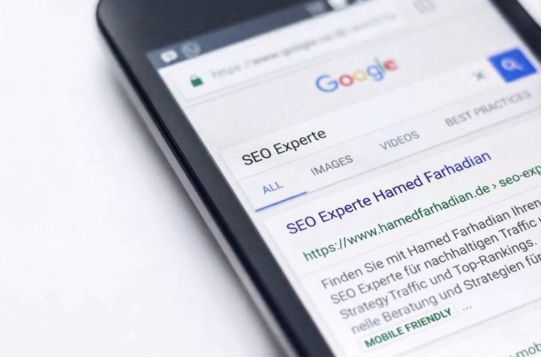 Smartphone showing a Google search for “SEO Experte”; the first result is Hamed Farhadian, labelled mobile-friendly.